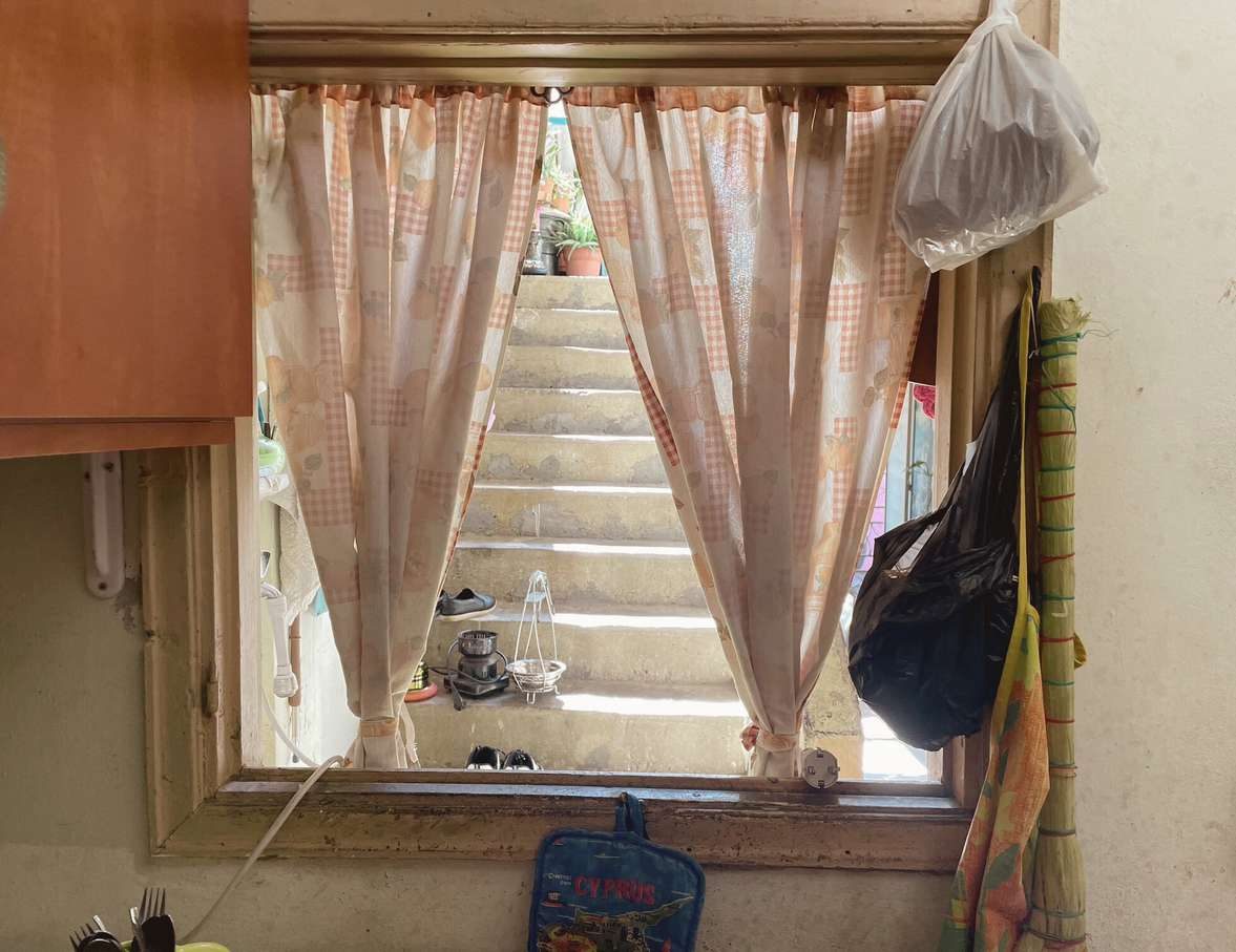A curtained window looking onto a stairwell